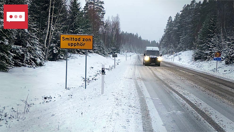 Vägskylt om smittad zon längs väg med snö där det kommer en bil.