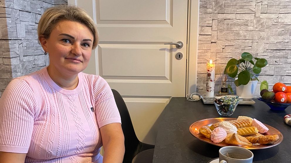 Tatiana, kvinna med  kort ljust hår vid en fikabord.