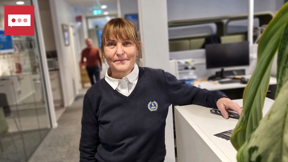 Kvinna står i kontorslandskap och lutar sig med ena armen på ett skåp.