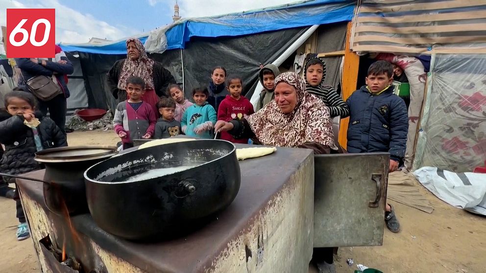 Kvinna i Gaza bakar bröd i en vedeldad ugn.