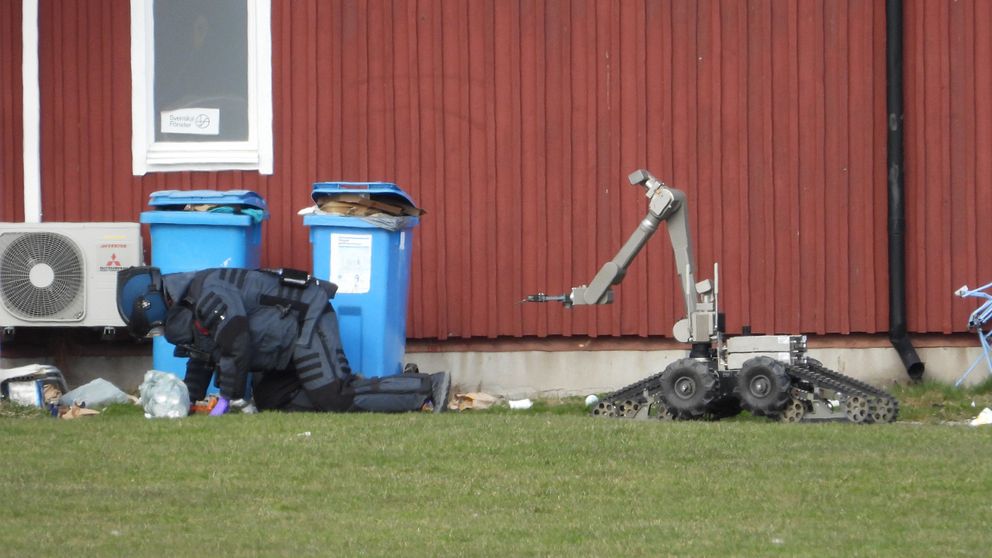 Bombtekniker och robot vid röda byggnaden.