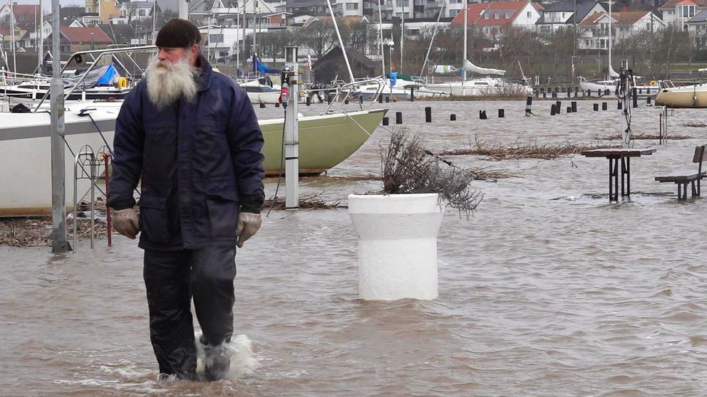 en båtägare går i översvämningen i ängelholm