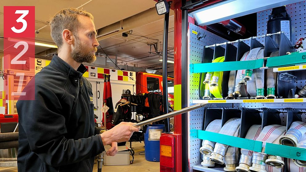 Brandingenjören Anton Hörnqvist visar en pulverlans vid brandbilen på stationen i Sundsvall.