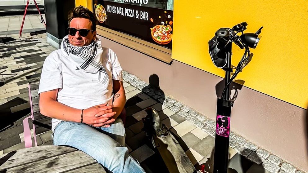 Man bredvid elsparkcykel