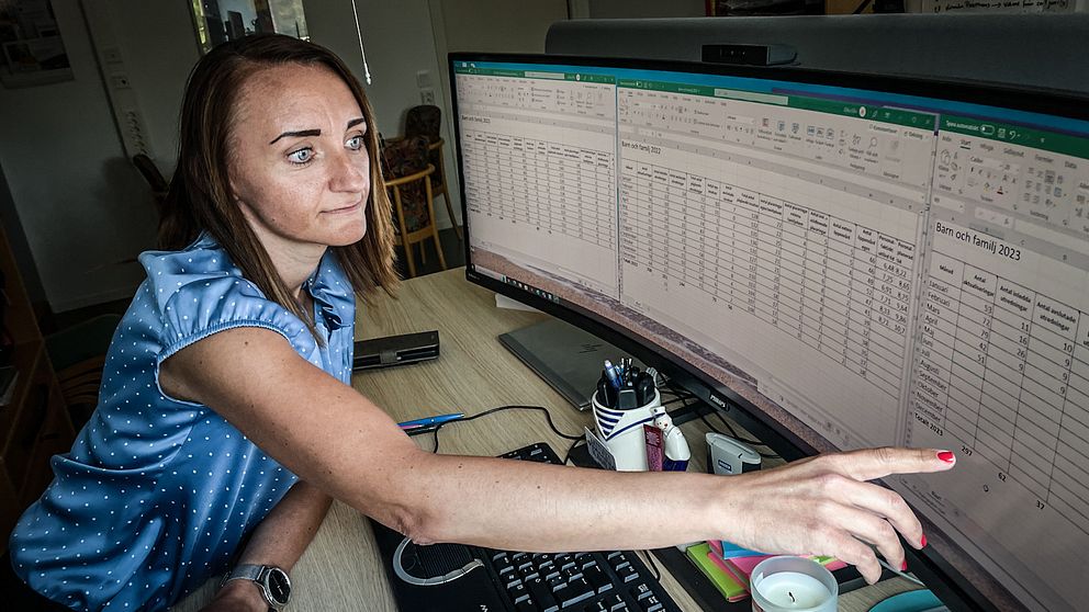 Zilha Fific är enhetschef på IFO Barn och familj vid Rättvik kommuns socialförvaltning. Hon har p åsig en blå kortärmad blus och pekar på en datorskärm med kalkylbladsark.