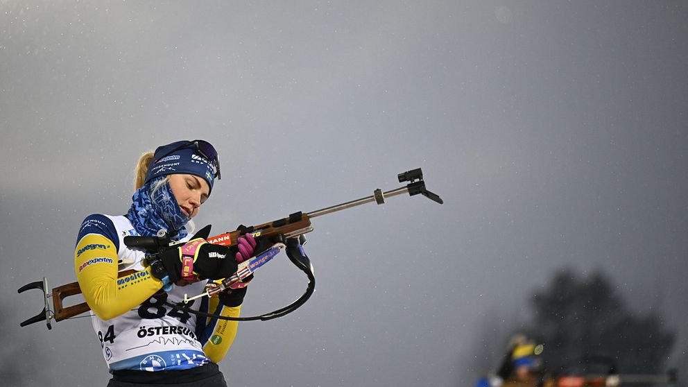 Skidskytten Tilda Johansson klädd i landslagsdress gör sig redo för att skjuta på tävling.