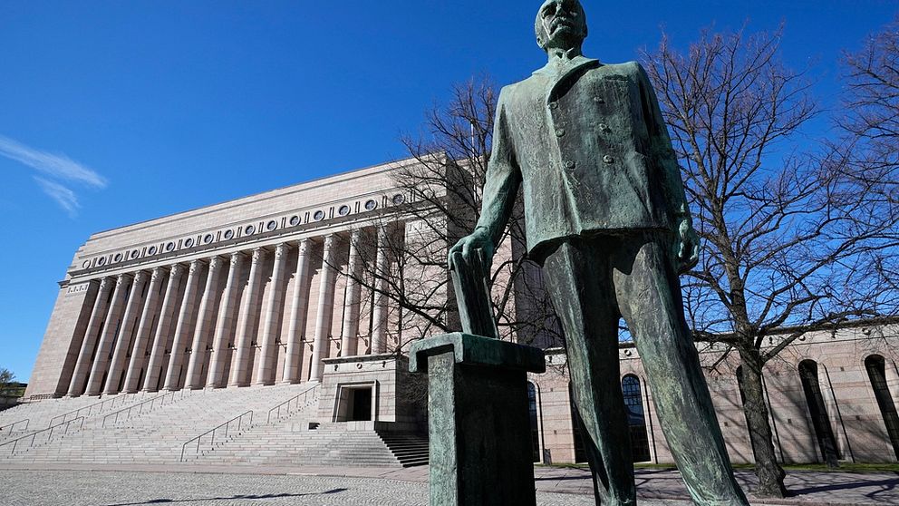 En stor bronsstaty framför Finlands riksdag