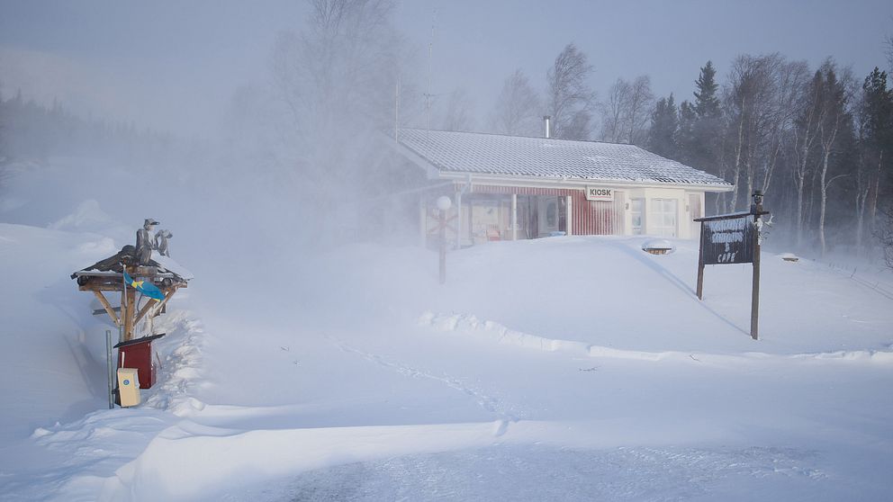 En röd stuga i Stekenjokk där det drevar mycket snö.