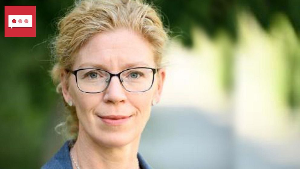 docent Sandra Friberg: En kvinna med glasögon tittar in i kameran med oskarp bakgrund
