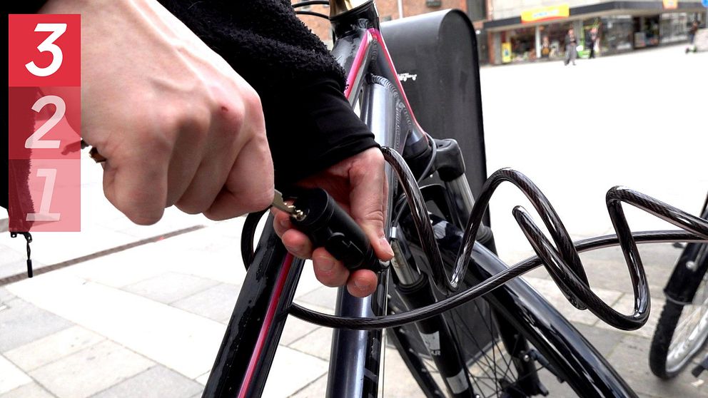 en cykel med lås och en person som låser upp