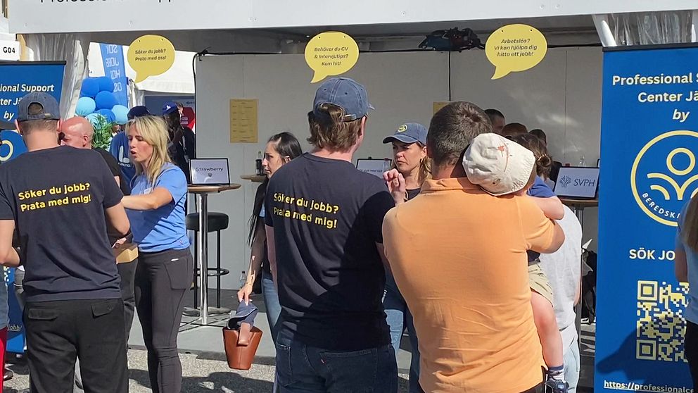 Personer med texten ”Söker du jobb? Prata med mig” på ryggen på t-shirt, framför tält för arbetssökande under Järvaveckan