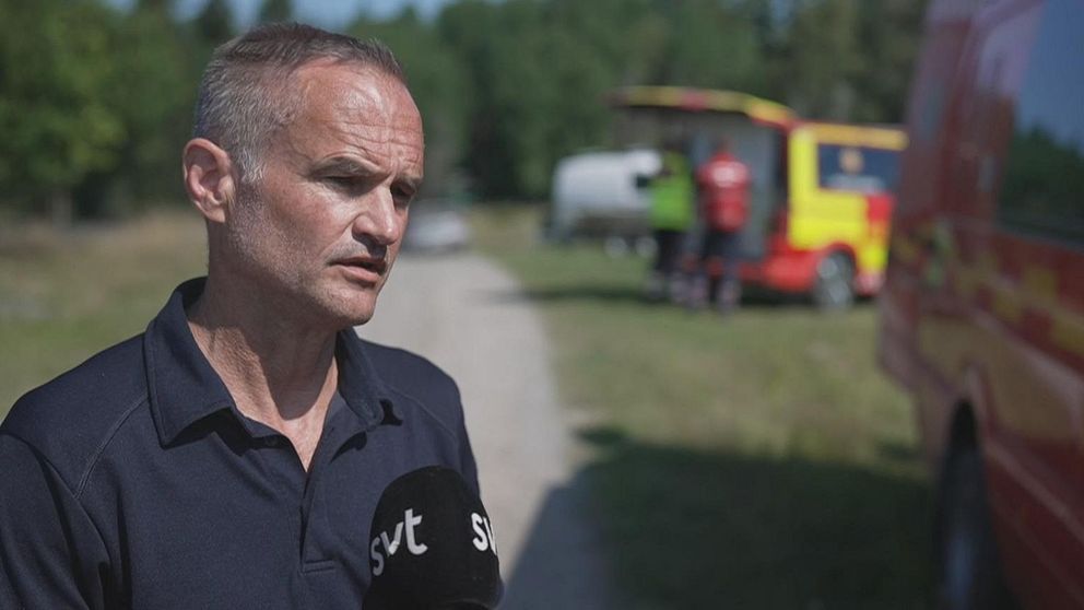 Man står framför räddningstjänstfordon