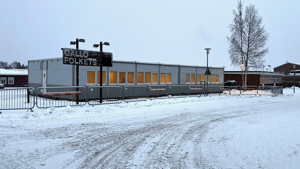 En barackbyggnad omgiven av snö och vinterlandskap.