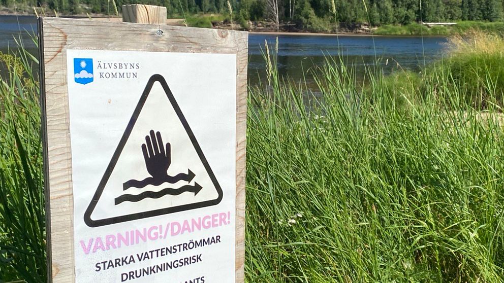 En varningsskylt om starka strömmar vid olycksplatsen i Älvsbyn där en man och ett barn omkom.r
