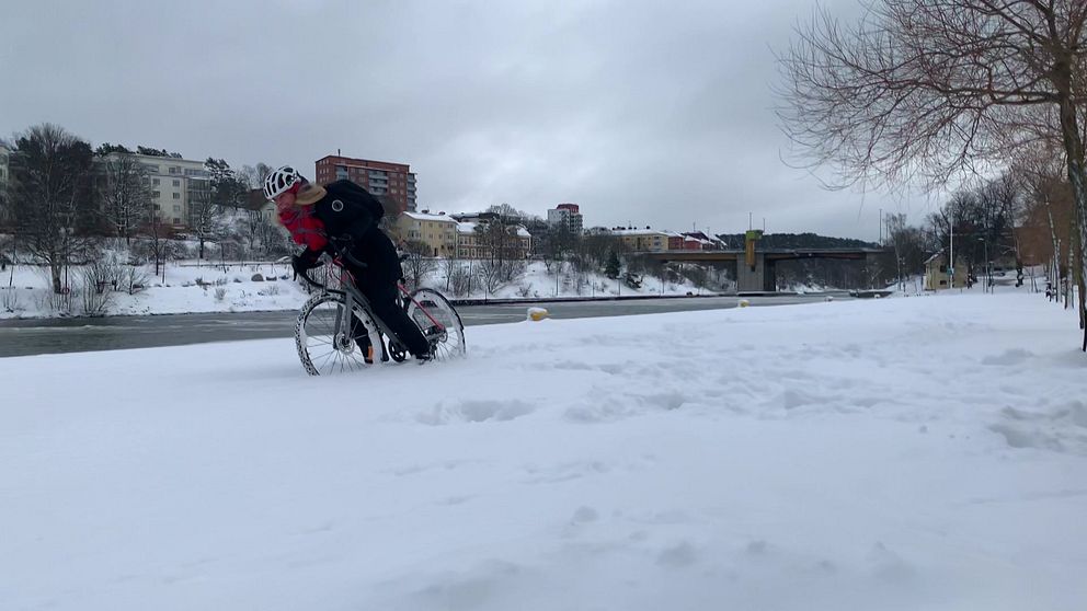 Vintercykling, en kvinna på cykel kämpar sig fram i snö