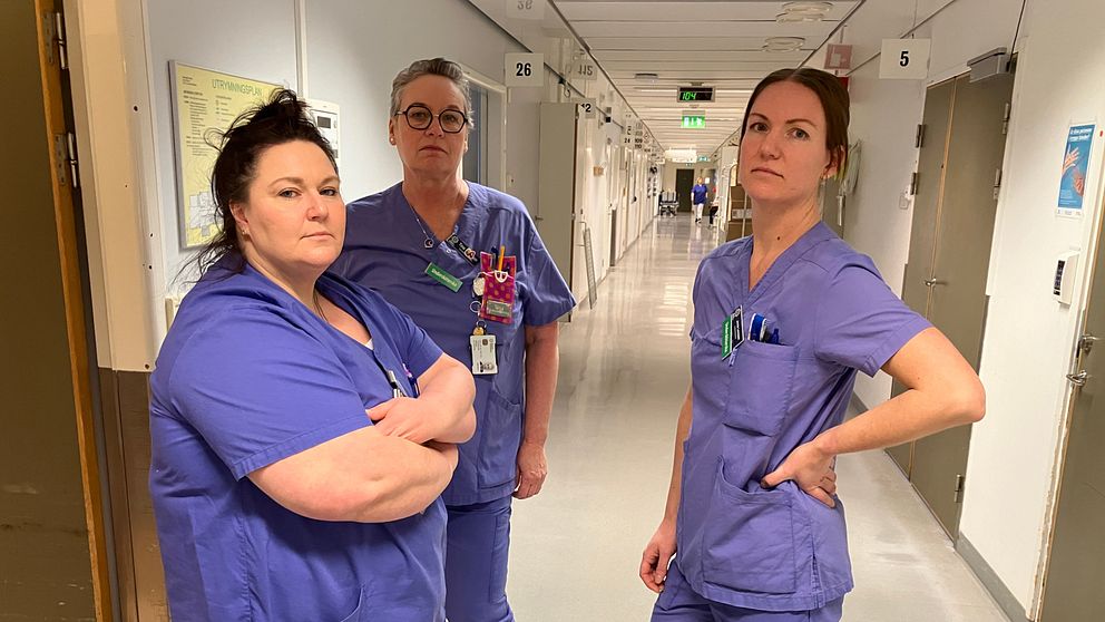 Tre sjuksystrar i blå sjukhuskläder.