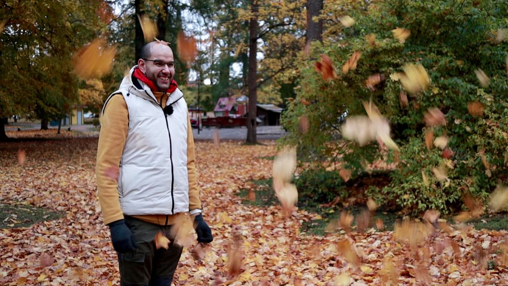 Alexander Fahssi kastar löv omkring sig och skrattar