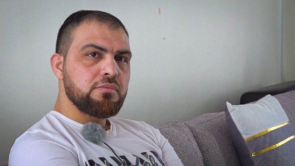 Mahmoud Alebrahim från Syrien sitter i sin soffa i sin lägenhet i Hylte och tittar in i kameran.