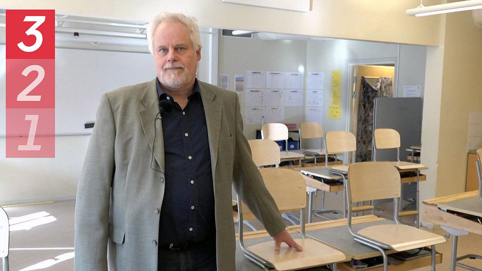 Joakim Graffner, rektor, står i ett tomt klassrum på Mariefreds skola. Han vilar handen på en stol som står uppställd på en bänk.