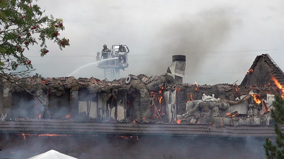 Brandmän på en stege försöker släcka moskébranden i Årby i Eskilstuna