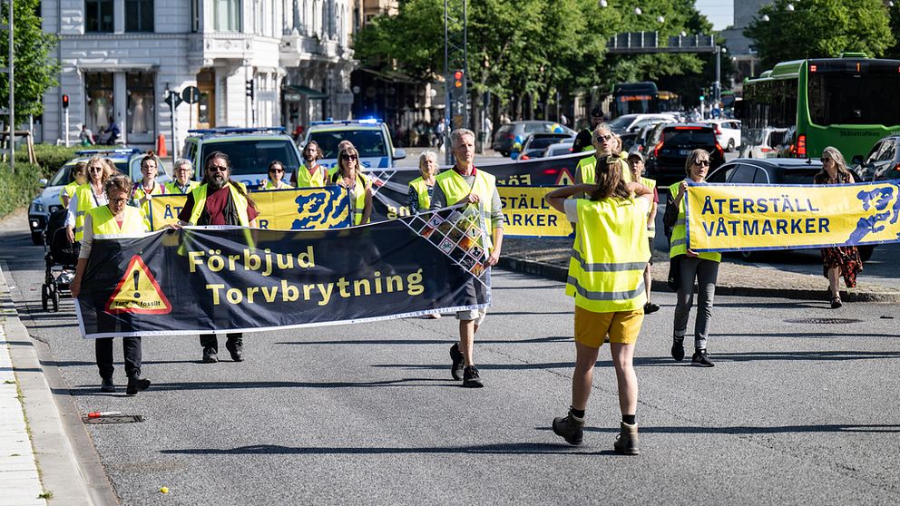 Människor protesterar på en gata med stora banderoller