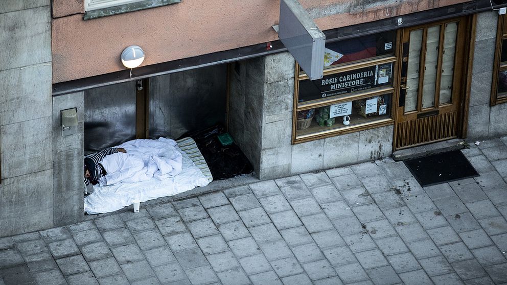 Hemlös person som sover ute på gatan.