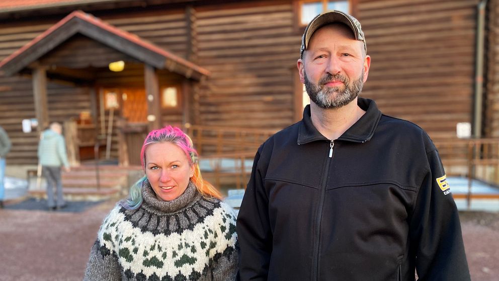 man och kvinna framför stort timrat hus(orsa hembygdsgård)