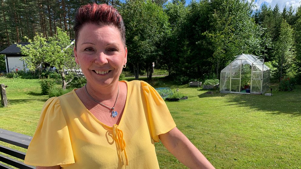 Sångerskan Anki Strandberg står i sin trädgård