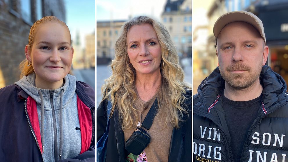 Tre personer står i en upplyst miljö. Den första personen har på sig en grå sweatshirt med en jacka över. Den andra personen har långt, vågigt hår och bär en svart axelväska. Den tredje personen har på sig en mörk jacka och en keps. Bakgrunden är suddig och visar en stadsrik miljö.