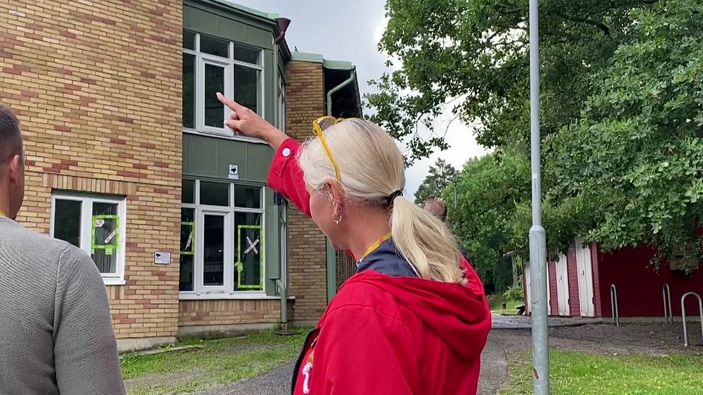 En kvinna som pekar upp mot taket