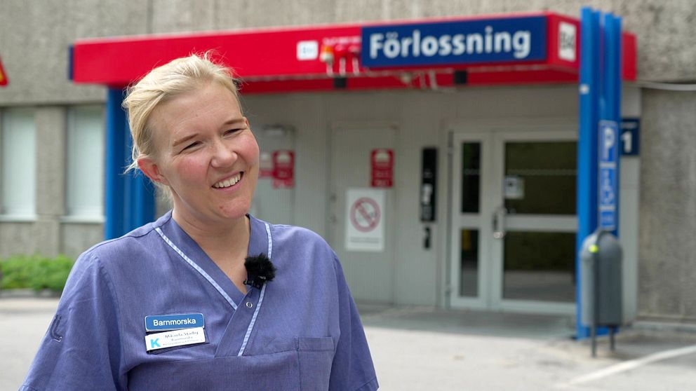 Portrttbild på barnmorskan Mikaela Stadig som är blond, har rosiga kinder och ett stort leende.