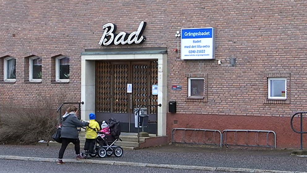 En kvinna skjuter en barnvagn framför sig, på väg in till badhuset i Grängesberg.