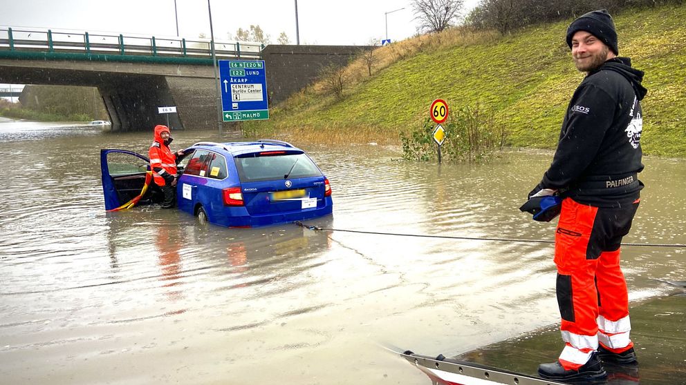 Två personer som bärgar en bil i Arlöv som har hamnat i vatten.