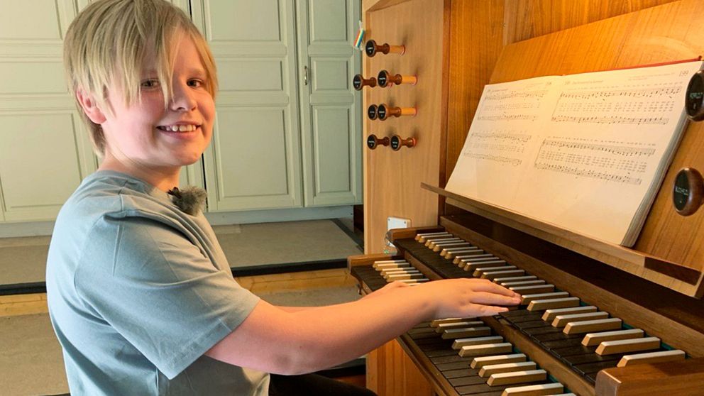 Pojke sitter vid orgel