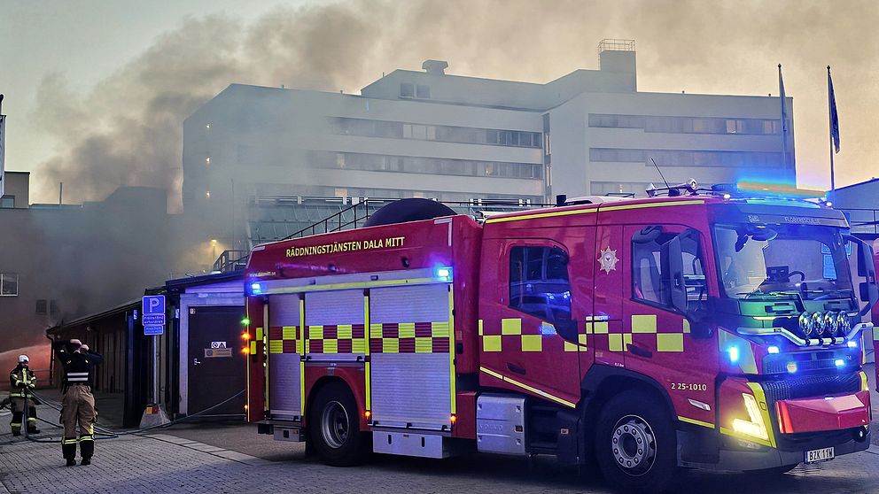 en brandbil framför en byggnad och brandrök