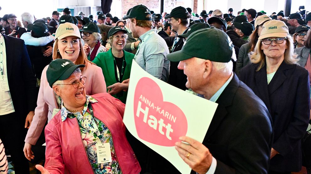 Människor i folkmassa. En person håller skylt med texten ”Jag älskar Hatt” på rosa hjärta.