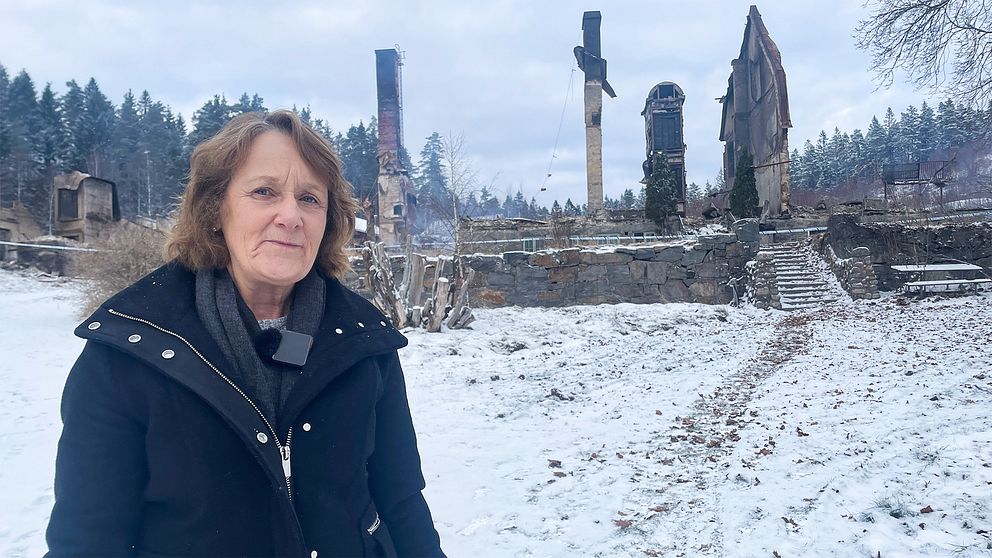 Gull-Britt Antonsson Söderberg står framför det nedbrunna sanatoriet i Rävlanda.