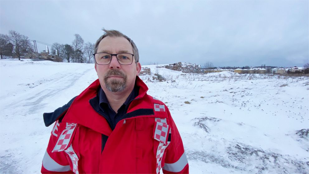 Mårten Eskilsson i röd jacka från räddningstjänsten står vid platsen där kungsladugården i Mariefred låg innan den brann ner