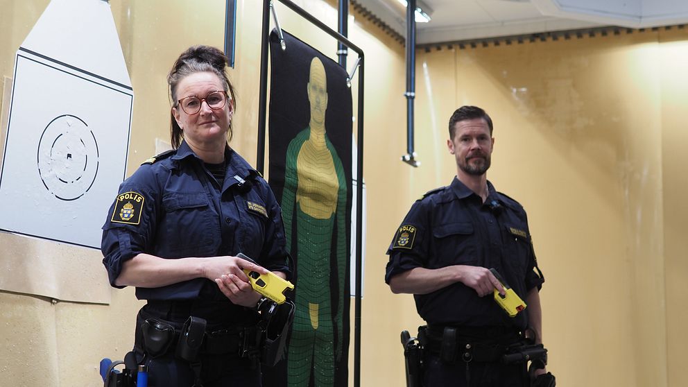 två poliser står med elchockvapen