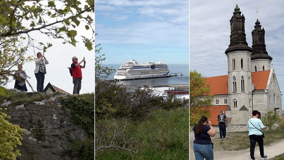 Turister står på en höjd och fotograferar. Ett fartyg syns i hamnen. Visby domkyrka.