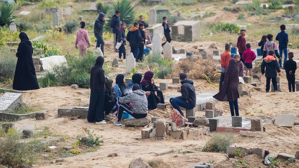 Människor sörjer sina döda närstående på en gravplats i Gaza.