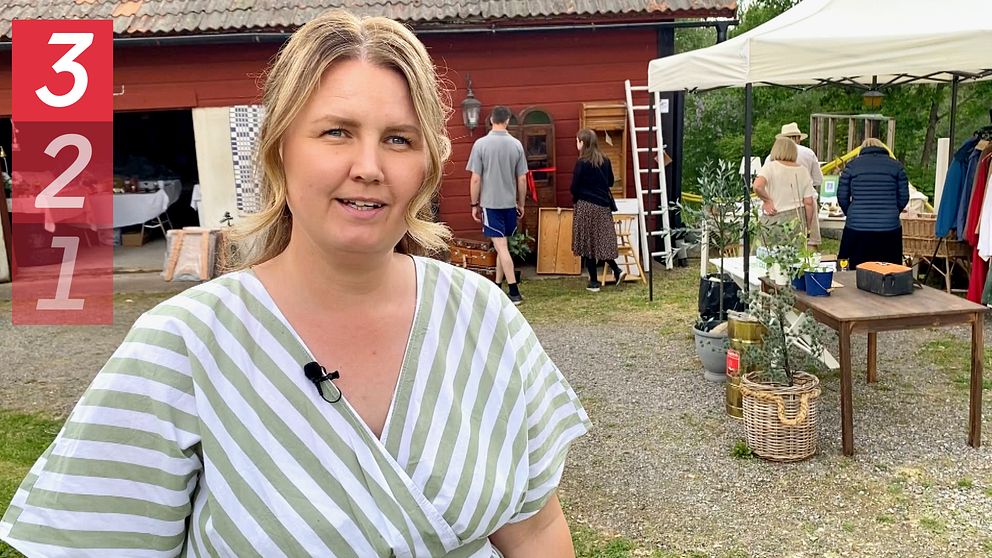 en kvinna framför en loppislada där människopr fyndar i bakgrunden