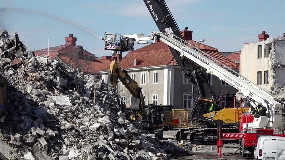 Flera maskiner och fordon river ned ett hus i Kirunas gamla centrum.