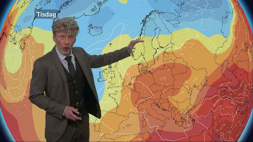 En bild på Pererik Åberg stående framför en röd-, orange- och blåfärgad väderkarta.