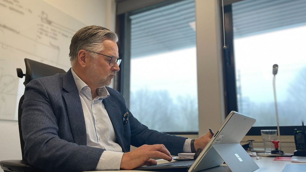 Christian Alexandersson tf kommundirektören i Bjuv sitter framför en dator i kommunhuset.