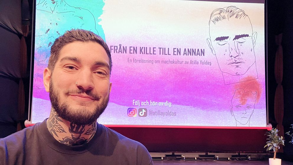En person, Atilla Yoldas,  sitter framför en stor scen med en presentation som visar titeln ”FRÅN EN KILLE TILL EN ANNAN” och texten ”En föreläsning om människo­kultur av Atilla Yoldas”. Bakgrunden är färgglad med illustrationer och information om att följa föreläsningen på sociala medier.