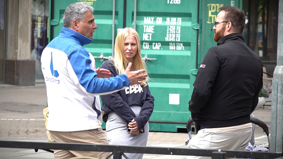 Tre personer pratar i gatumiljö, en person med ”ebba” på tröjan ”Liberalerna” på en annan