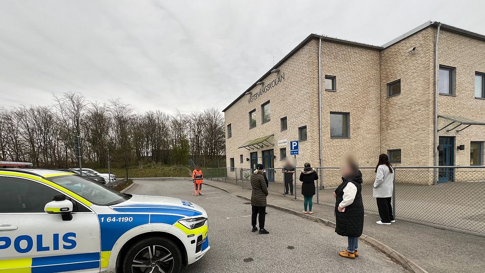 Personer och en polisbil framför Västervångskolan i Trelleborg.