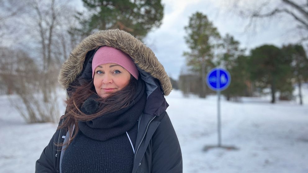 Eva Malm, mamma till en autistisk 12-åring, står vid en gångväg i ett blåsigt Östersund.