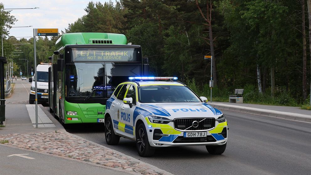 Bussen som blev träffad av skotten står bakom en polisbil.